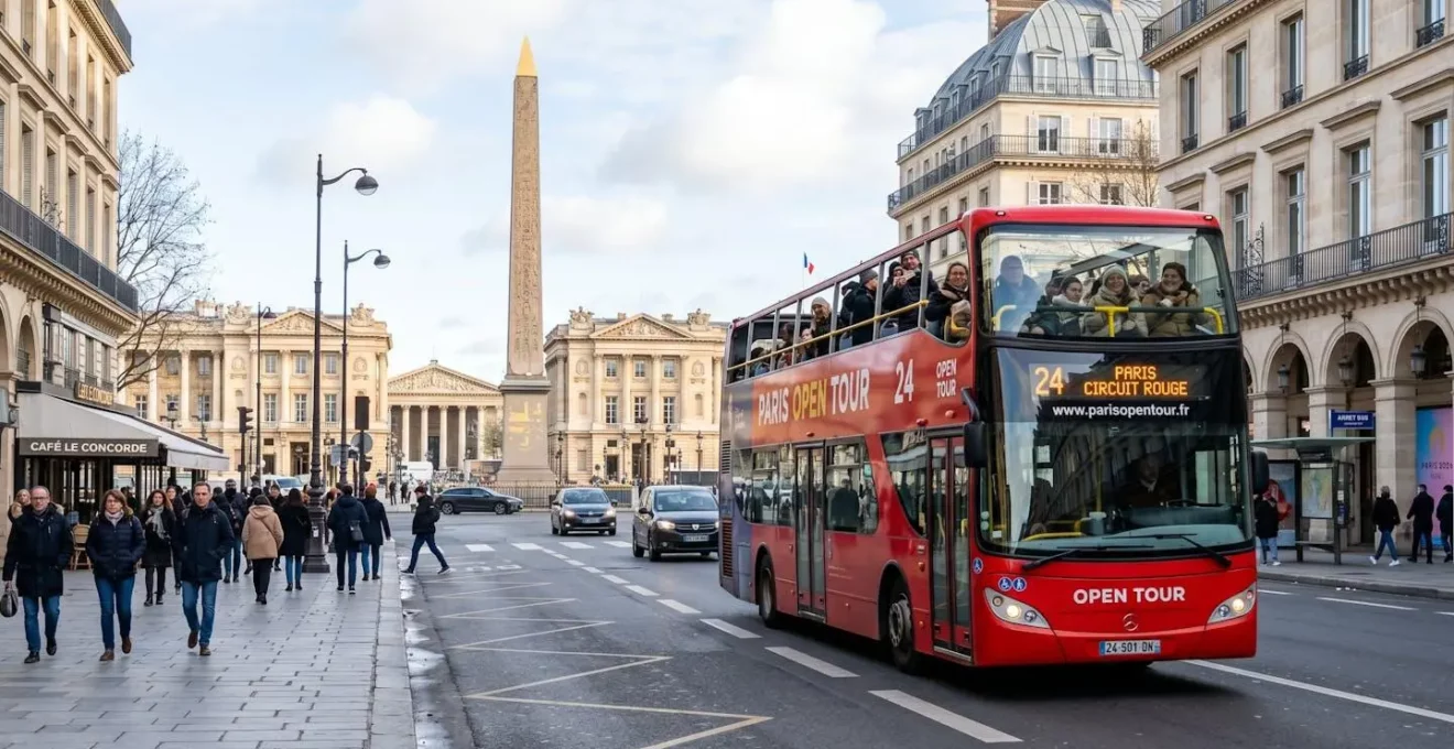 A red double-decker sightseeing bus passes along a Paris street near a historic monument on a bright winter morning